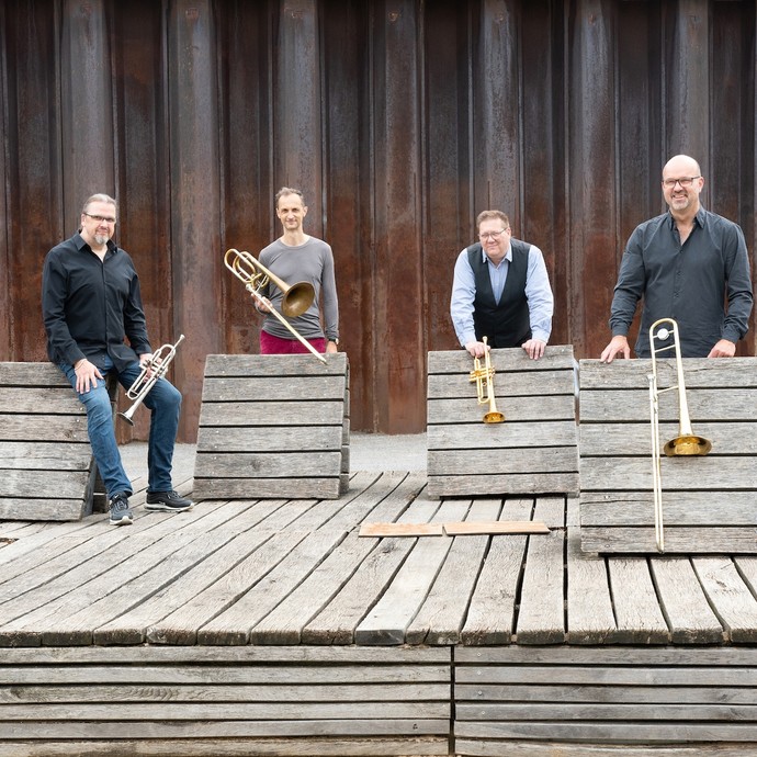 Vier Mitglieder der Band Brassfabrik mit Instrumenten. Vier Mitglieder der Band Brassfabrik mit Instrumenten.